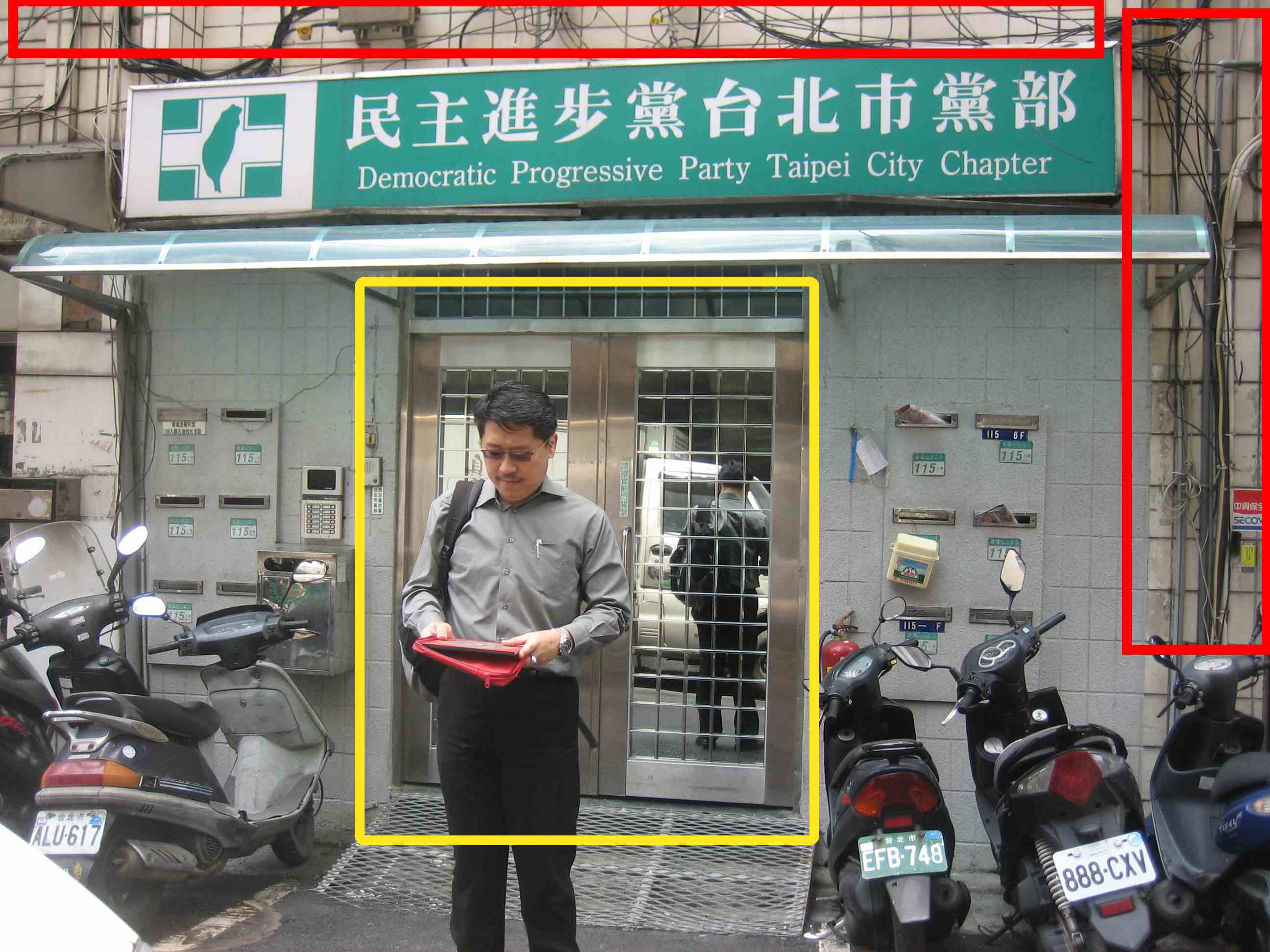 Taipei City 300409 台北民进党5-1(modified 3) Democratic Progressive Party Taipei Chapter. The Main door is too small represents narrow mindedness. Unorganized Wiring at the facade represents disorganized ideas and presentations of politics.